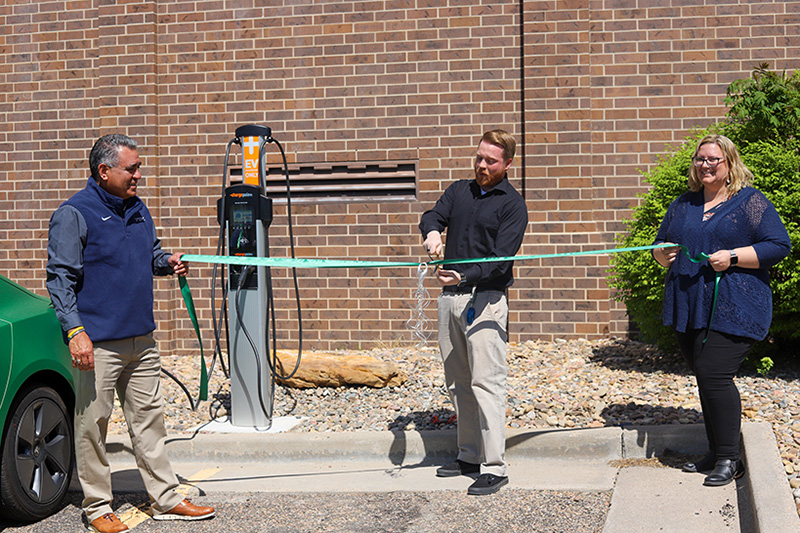 Allan Nolan cutting ribbon at new electric vehicle charging station.