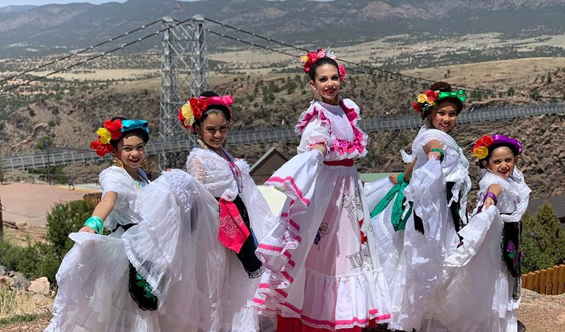 Dancers posing in traditional mexican folk dance regalia.