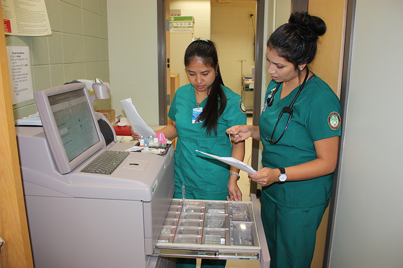 Two Otero Nursing Students check charts to determine correct amounts of medication to give out.