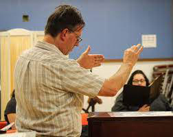 Dean Rees, Otero College Choir Director, directing students as they sing.