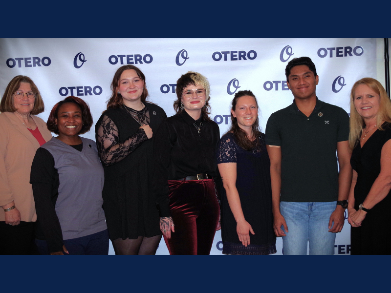 MLT Nursing Students and their instructor stand in front of an "Otero College" branded wall