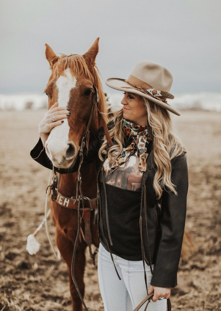 Jennifer Pollmiller stands next to a horse and is smiling